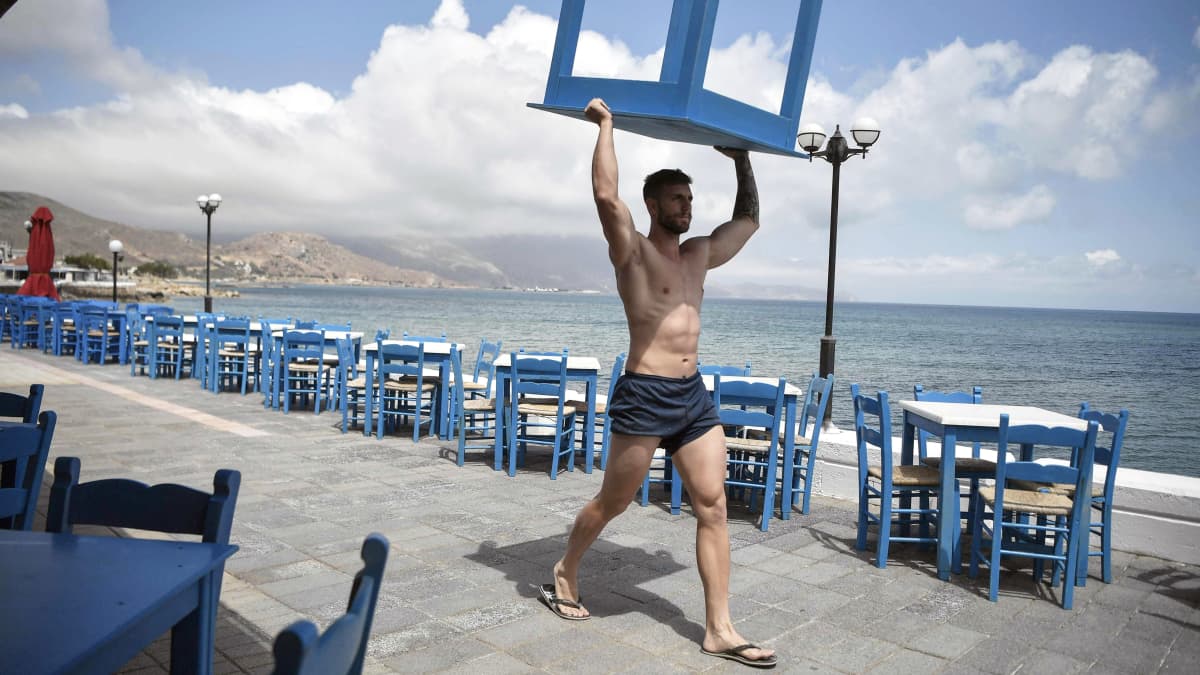 Työntekijä kantaa pöytää Kreikassa.
