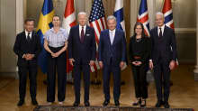Nordic prime ministers and the Finnish and US presidents, standing in a row with flags behind them.