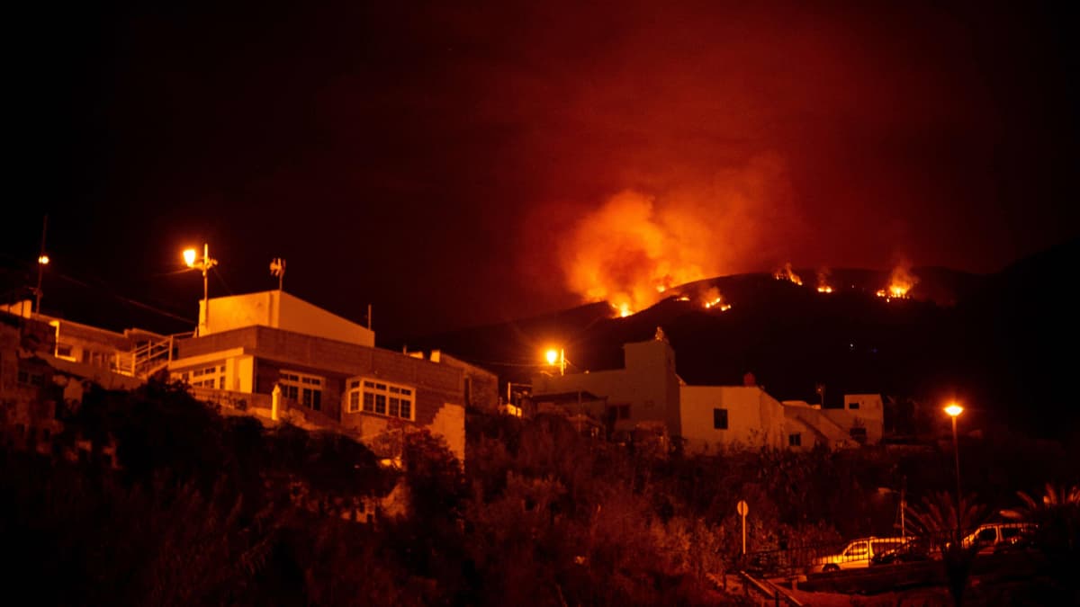 Metsäpalo  kukkuloilla talojen yläpuolella Guimarin laaksossa Teneriffan Kanariansaarella.