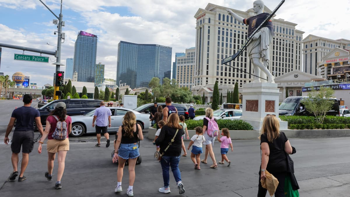 Legendaarisen Ceasars Palace -kasinohottelin patsas puettuna Vegas Golden Knightsin pelipaitaan. Ihmisiä kävelemässä kadulla hotellin edustalla.