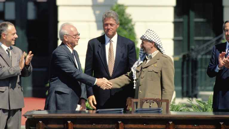 Yhdysvaltain presidentti Bill Clinton todisti Jitzhak Rabinin ja Jasser Arafatin historiallista kädenpuristusta Valkoisen talon pihalla 13.9.1993.