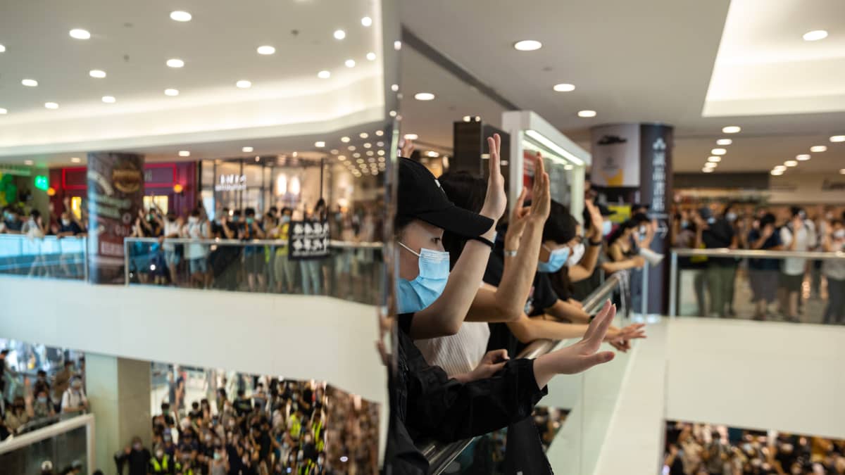 Mielenosoittajat viittovat katsojille ostoskeskuksessa järjestetyssä protestissa 10. toukokuuta 2020. 
