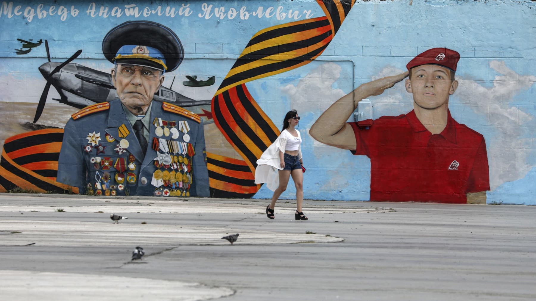 Nainen käveli heinäkuun lopussa venäläis-nationalistisen seinämaalauksen ohitse Jaltalla.
