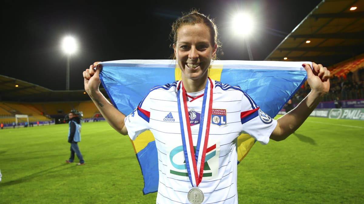 Lotta Schelin seisoo Ruotsin lipun kanssa.