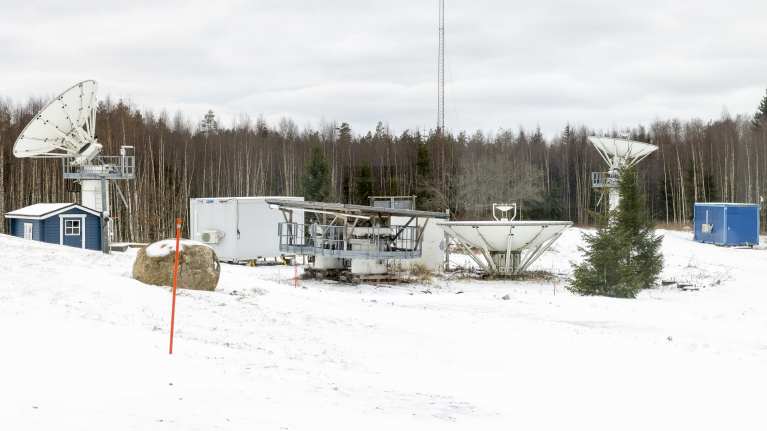 Radioteleskooppeja lumisessa maisemassa.