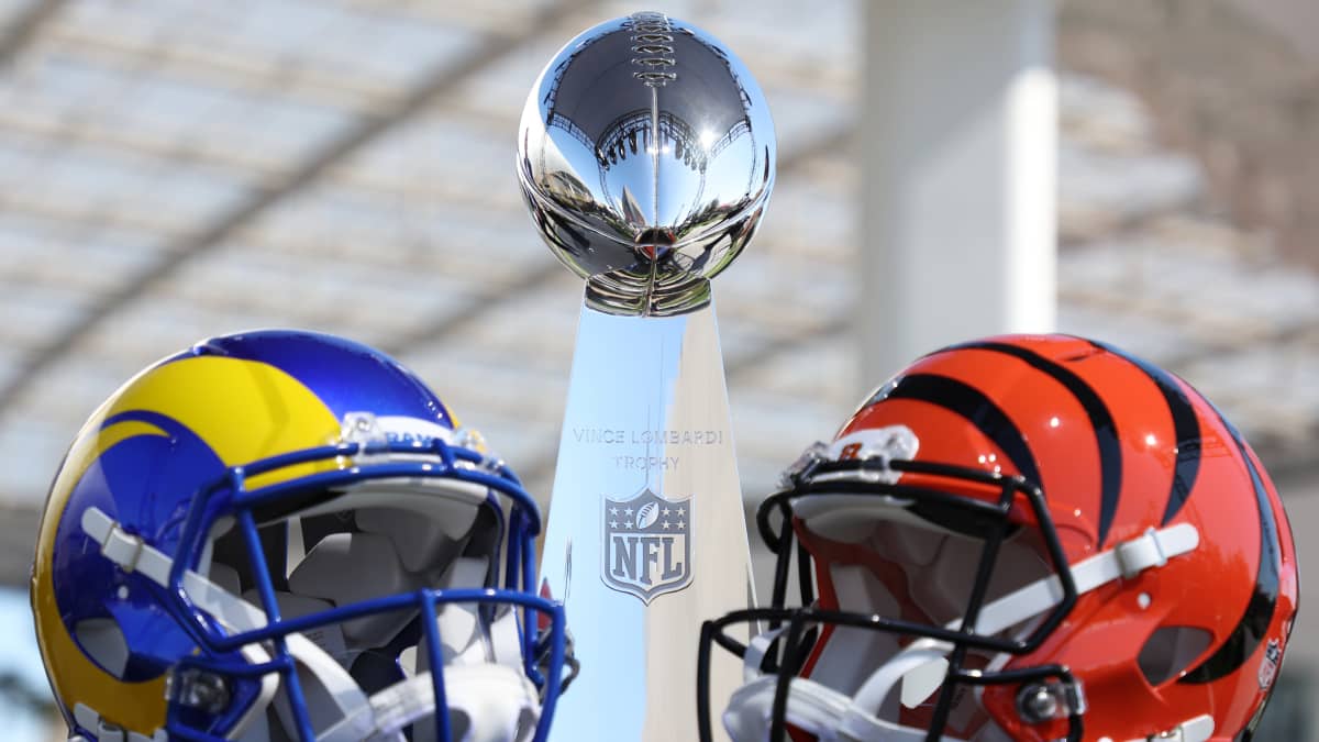 Super Bowlin ennakkokuva, jossa Ramsin ja Bengalsin kypärät ja mestaruuspokaali.