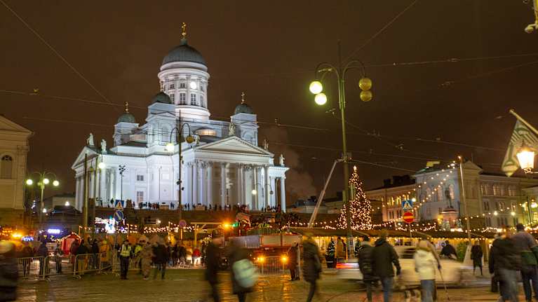 Wide nighttime photo of Helsinki Christmas Market, with Helsinki Cathedral in the background.