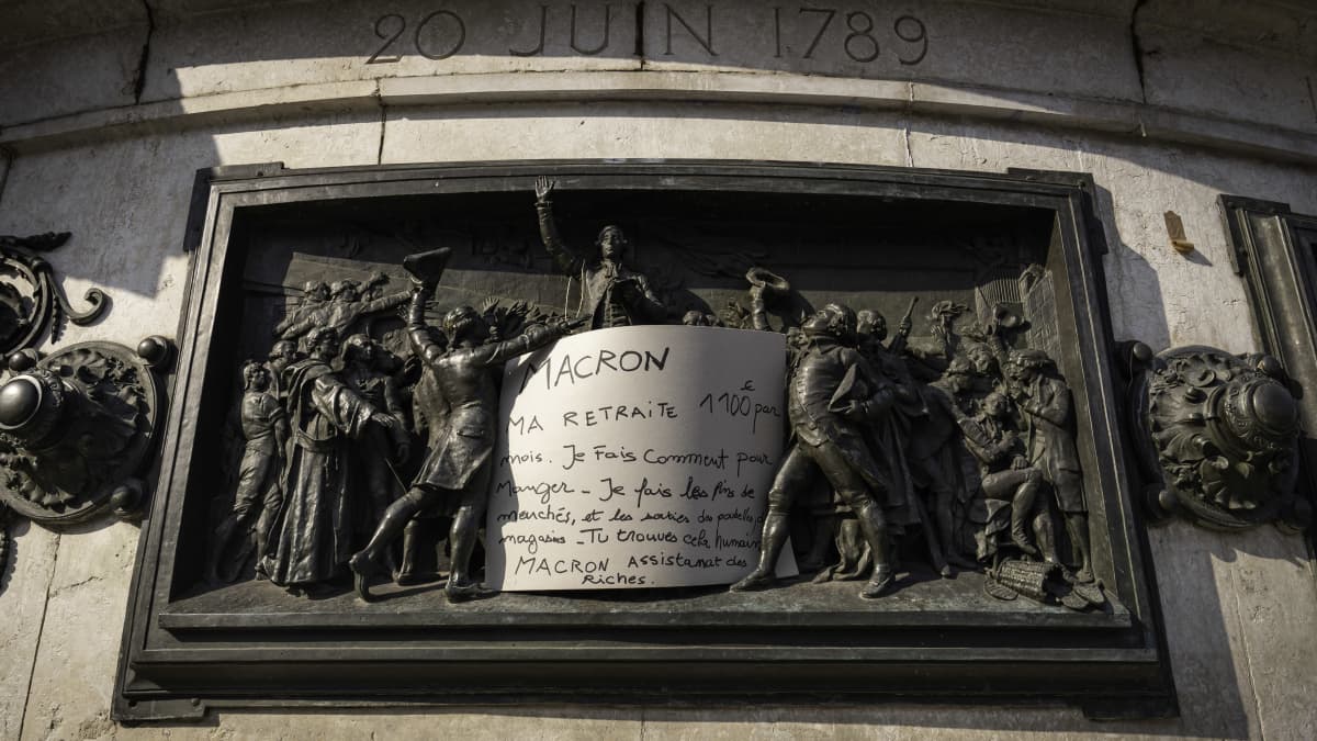 Tasavallan muistomerkki Pariisissa. Ammattiliitto CGT:n eläkeläismielenosoittajan jättämä viesti Macronille.