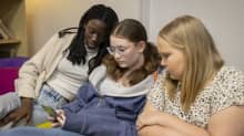 Helsinkiläiset koululaiset Manuella Federiko, Annabella Hienonen ja Nelly Hutri katsovat sosiaalisessa mediassa leviäviä väkivaltavideoita sohvalla istuen.