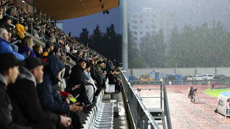 People in the stands and heavy rain.