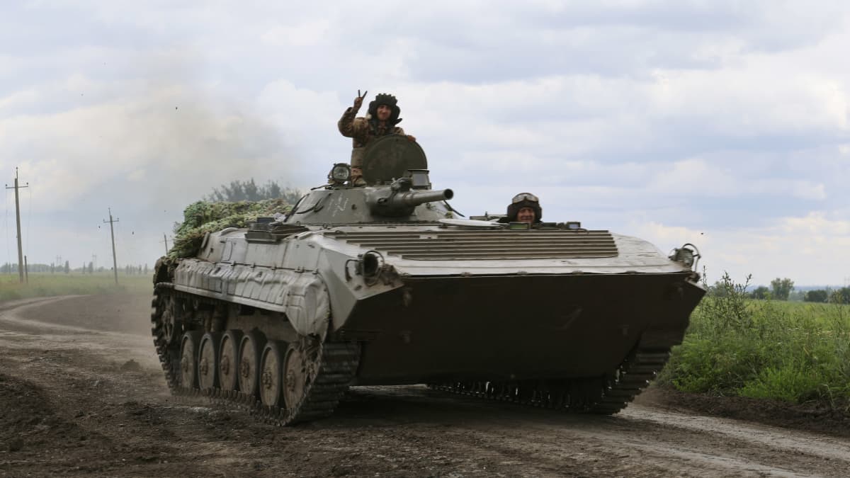 Ukrainalainen sotilas näyttää voitonmerkki panssaroidun miehistönkuljetusajoneuvon katolla lähellä rintamaa Bahmutissa.