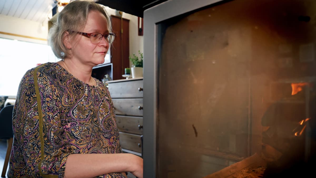 Enni Pöykkö katselee takkatulta kotonaan Mäntsälässä.