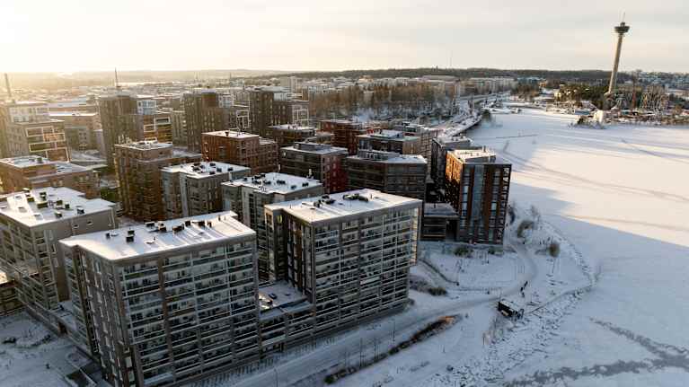 Ilmakuva lumisesta kerrostaloalueesta.
