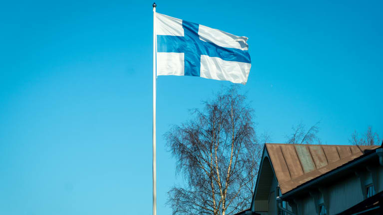 Suomen lippu liehuu tuulessa.