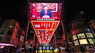 Kiinan presidentti Xi Jinpingin uudenvuodenpuhe näkyyvissä suuressa monitorissa kadulla Pekingissä.