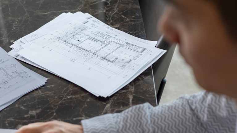 This is a paper about pinoissa pöydällä miehen työskennellessätietokoneella.