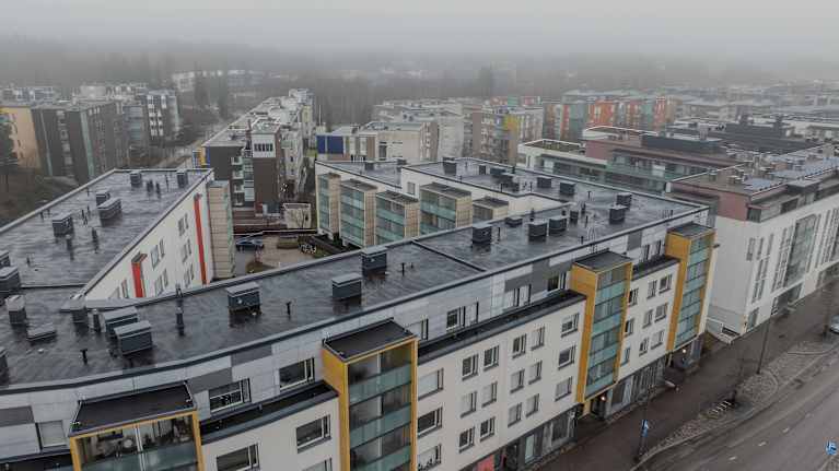 Ilmakuva kerrostaloalueesta sumuisena päivänä.