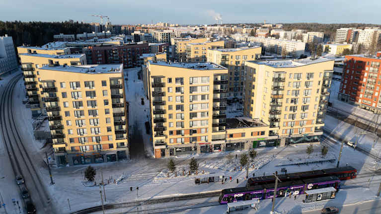 Ilmakuva lumisesta kerrostaloalueesta.