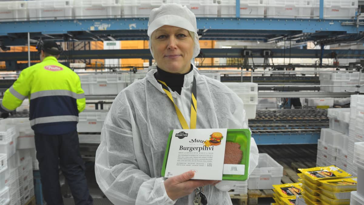Nainen pitää kädessään Poutun hernerouheesta tehtyä burgerpihvipakkausta.