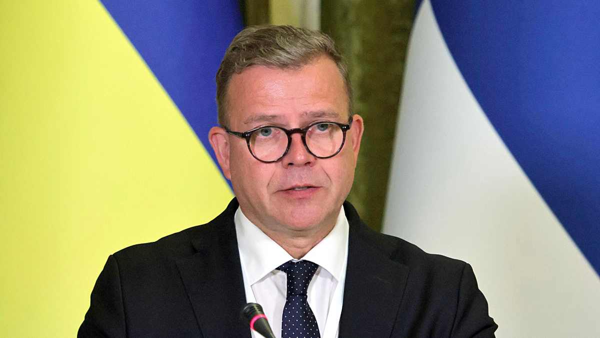 Pääministeri Petteri Orpo, taustalla Ukrainan ja Suomen liput. 