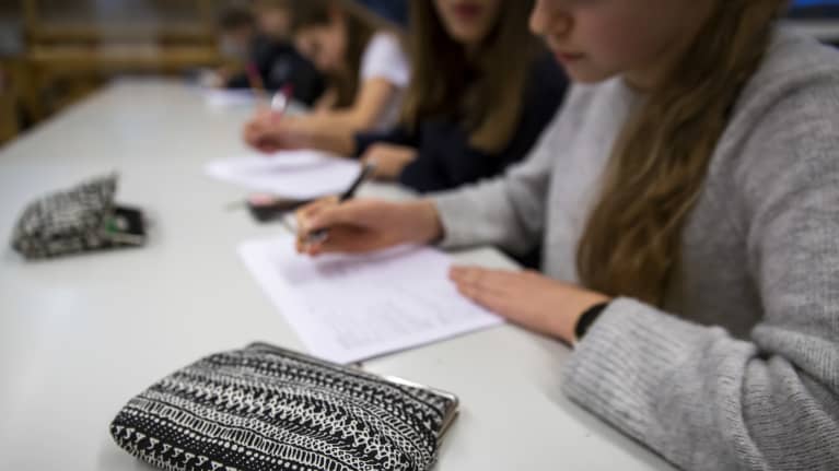 anonyymit oppilaat tekevät koulutehtäviä