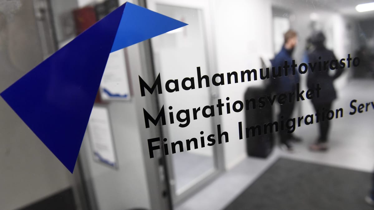 Migrin ulko-ovi teksteineen, oven läpi häämöttää pari asiakasta käytävällä.