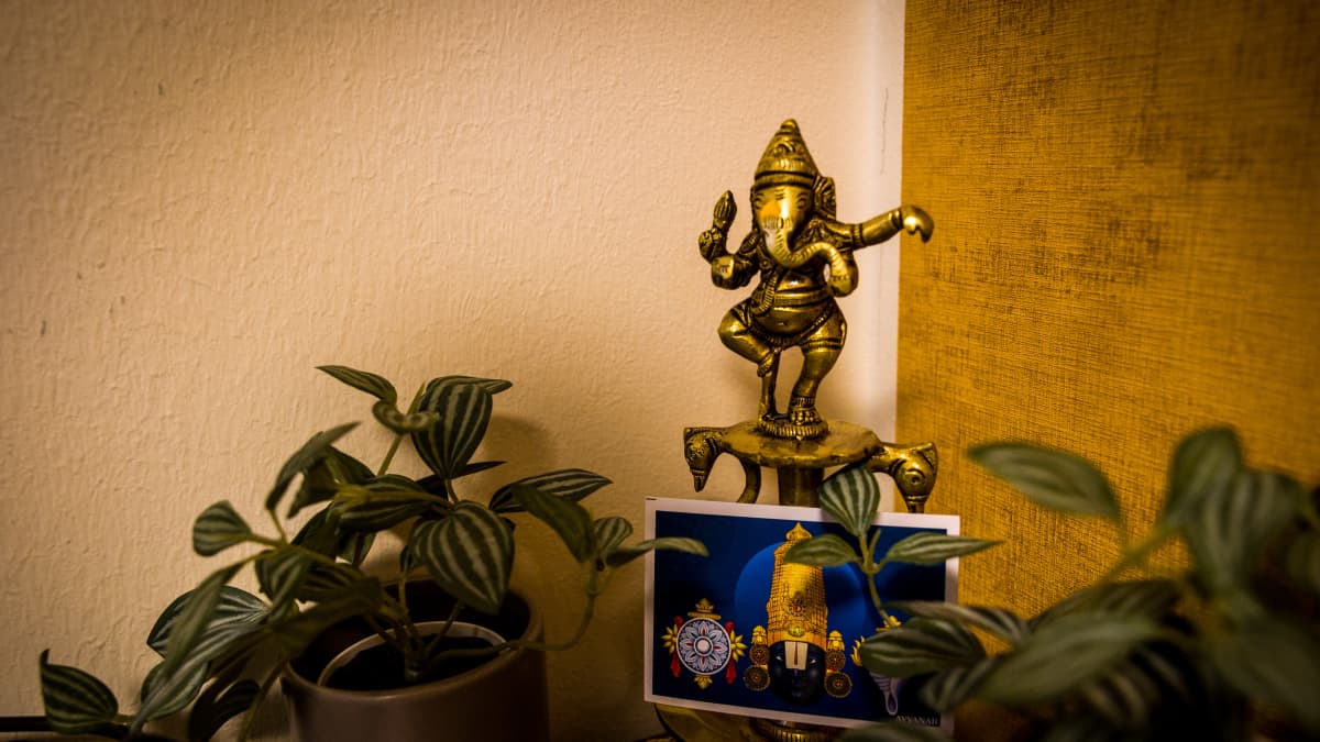 Jumalkuvia tyähuoneen nurkassa.  ylempi hahmo Lord Ganesha alempi kuvassa Lord Vishnu