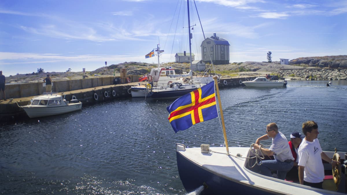 Boats in the water, some boasting flags of the region of Åland.