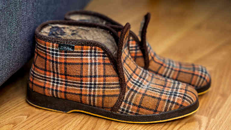 Ruutukuvioiset tossut lattialla.