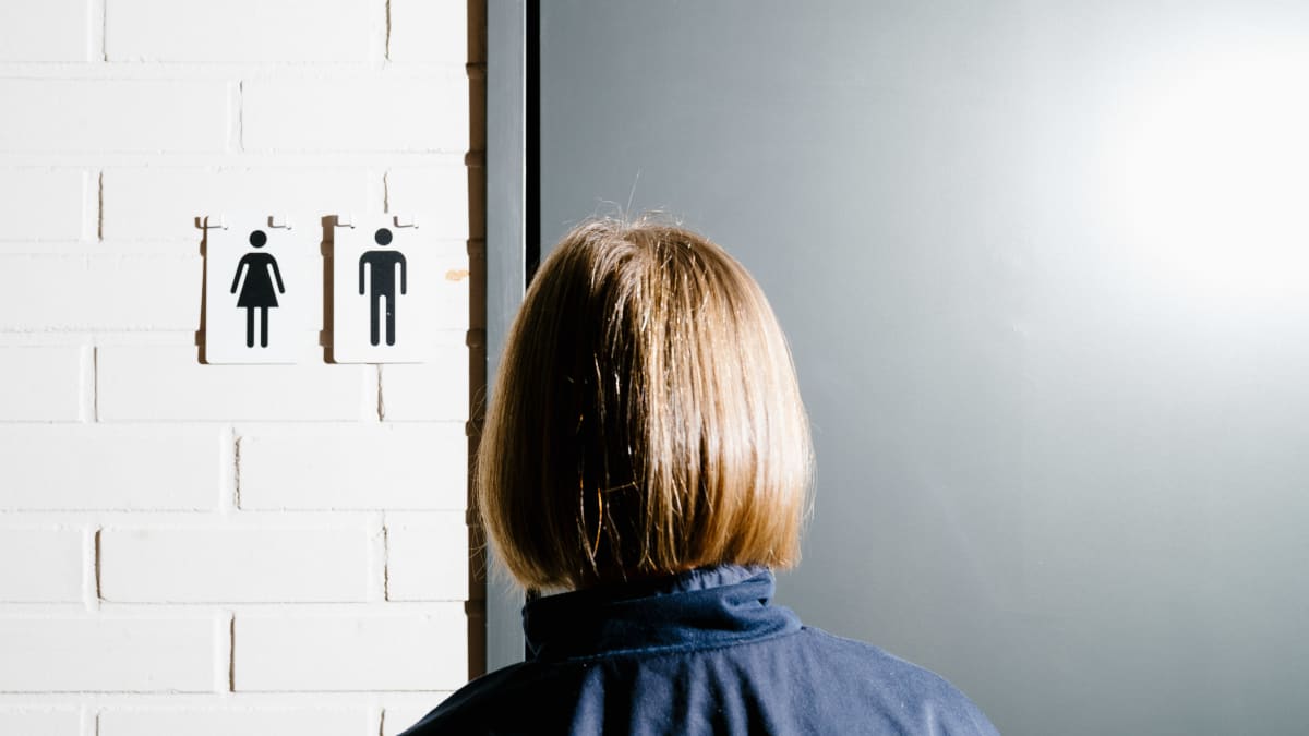 A woman standing in front of changing rooms.