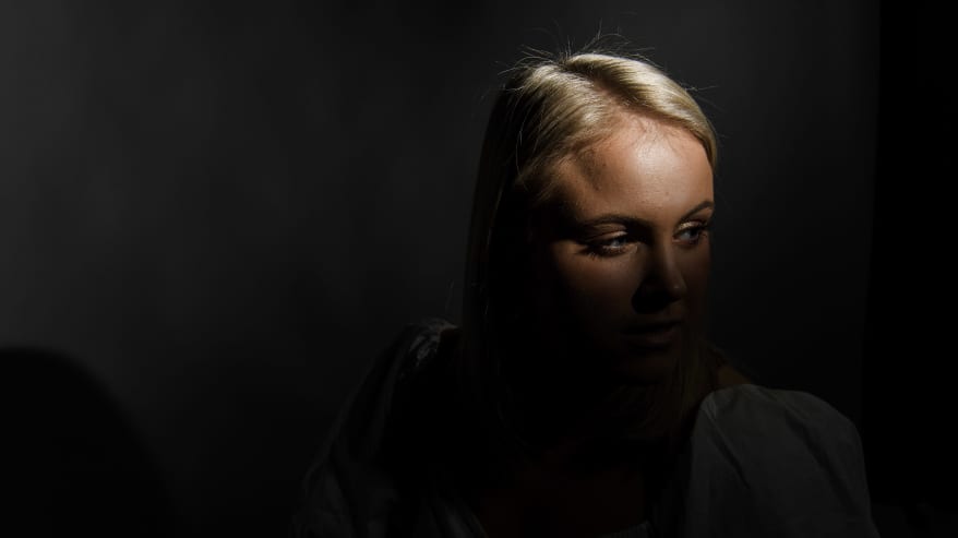 Kirjoittaja Nea Lundström poseeraa tummasävyisessä henkilökuvassa.