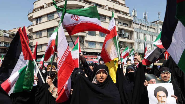 Iranilaiset heiluttavat Palestiinan ja Iranin lippuja Israelin vastaisessa mielenosoituksessa.