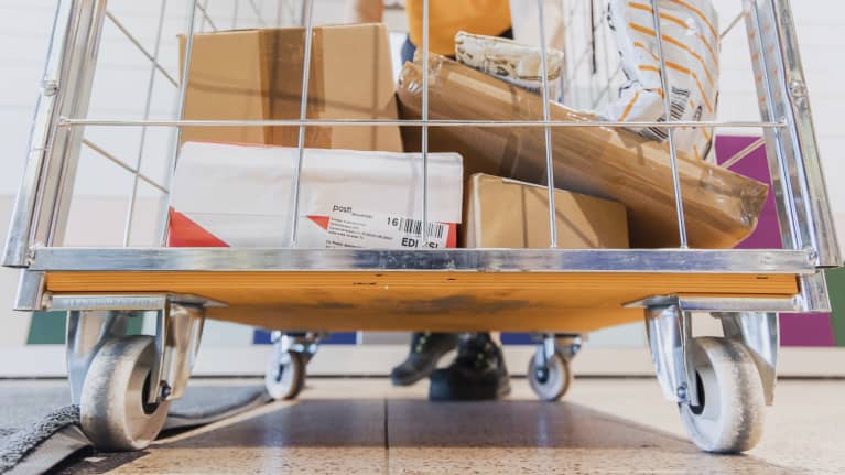 Postin pakettiautomaattiin meneviä pakettaja rullakon pohjalla.