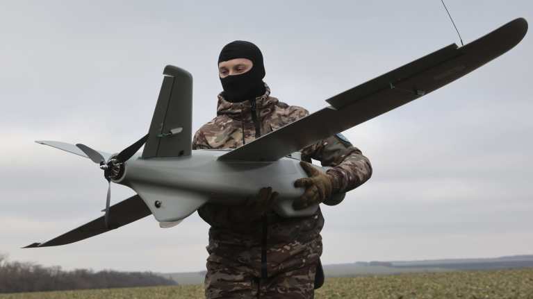 sotilas pitelee droonia kädessään