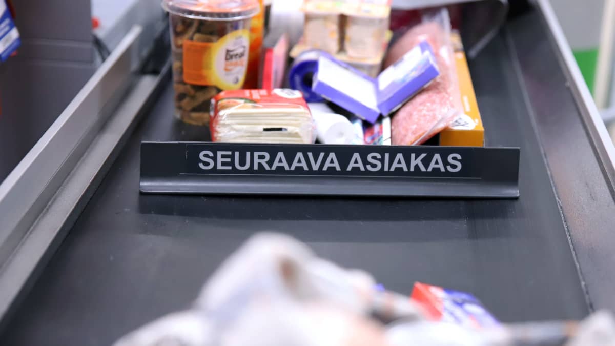 Photo shows food items on a supermarket conveyor belt.