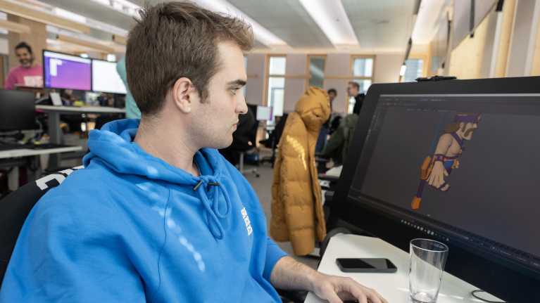 Nuori mies tekee tekee tietokonegrafiikkaa.
