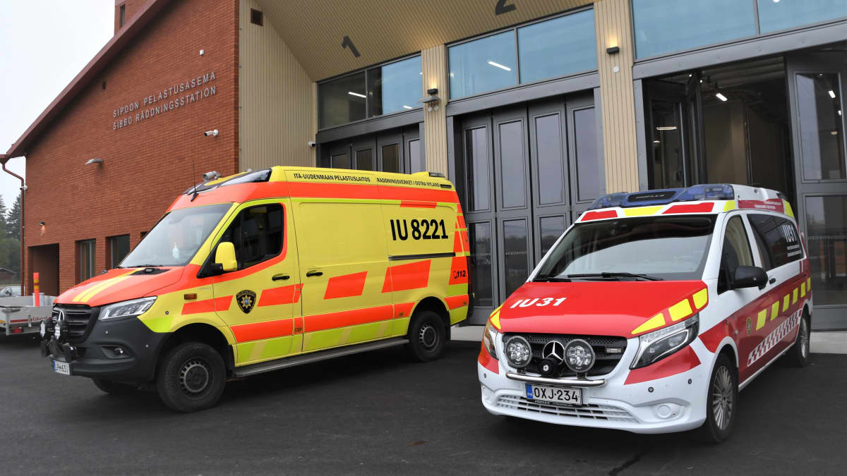 Två ambulanser utanför en nybyggd brandstation.