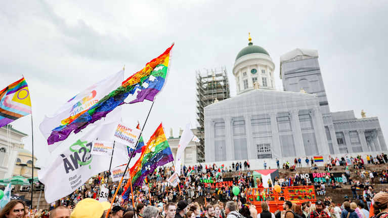 Pride-liput liehuvat Helsingin tuomiokirkon edessä.
