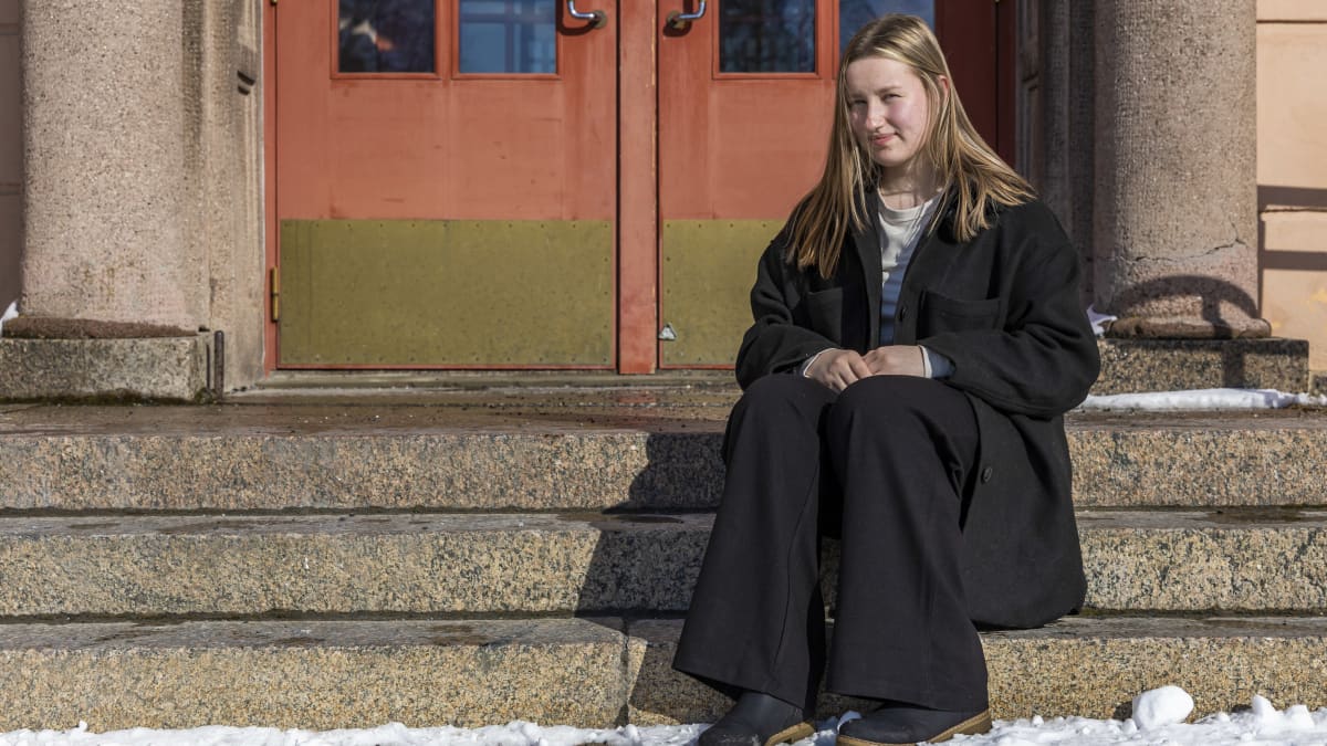 Abiturientti Sara Ylimäki istuu Kemin lyseon lukion kiviportailla.