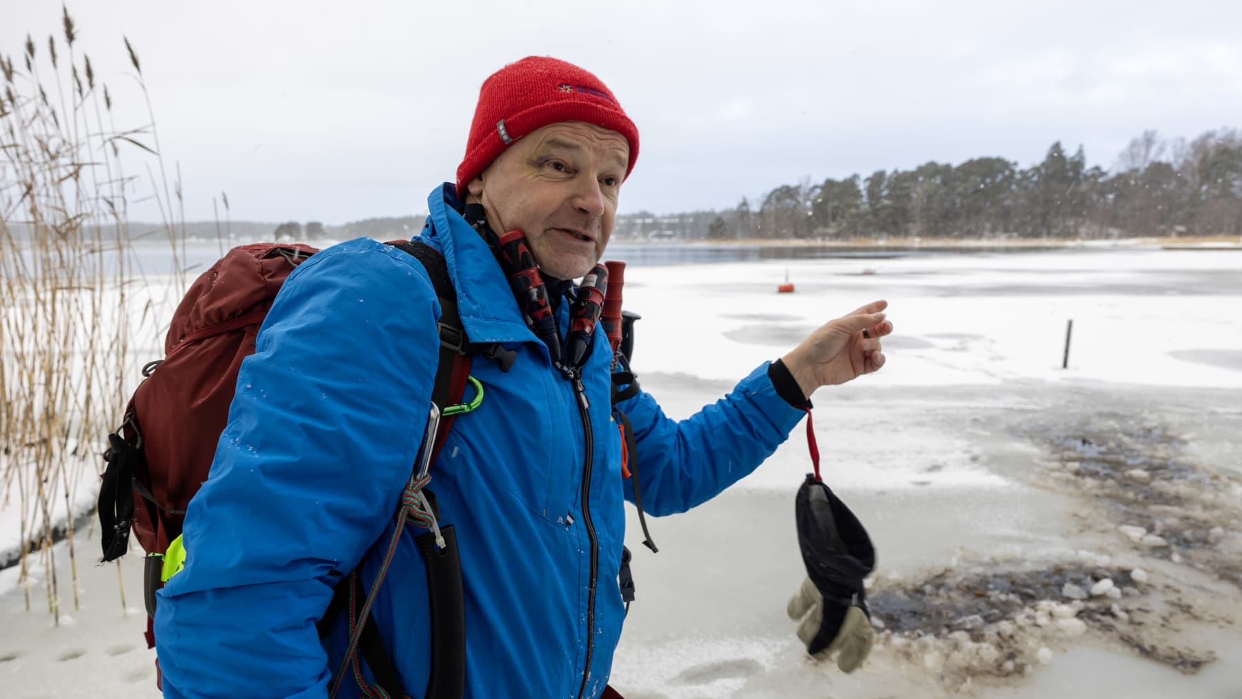 Tuomas Hannikainen seisoo rannalla ja osoittaa merellä olevaa jäätä.