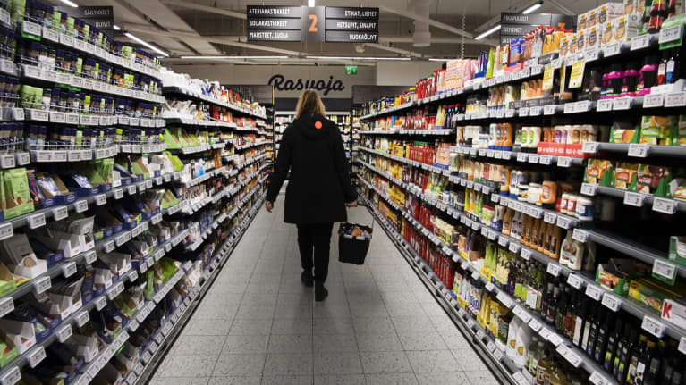 Asiakas kantaa ostoskoria ruokakaupassa.