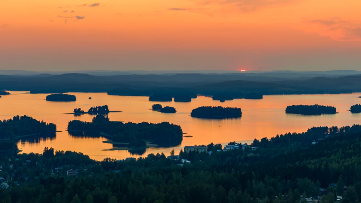 Kuvassa näkyy järvimaisema ja auringonlasku.