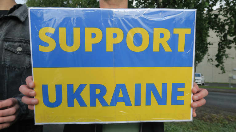 Ukrainaa tukeva kyltti mielenosoittajan kädessä.