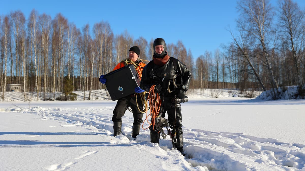 Sukeltaja Kari Back avustajansa Kimmo Kunnarin kanssa poistumassa avannolta Rovaniemellä.