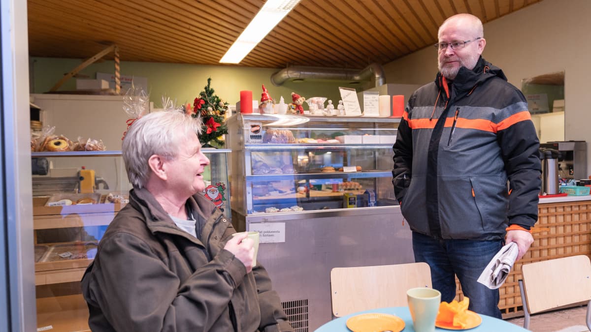 Jari Lindström keskustelee kahvilassa Aki Haimin kanssa