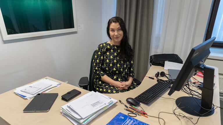 Ministeri Emma Kari istuu työpöytänsä ääressä.