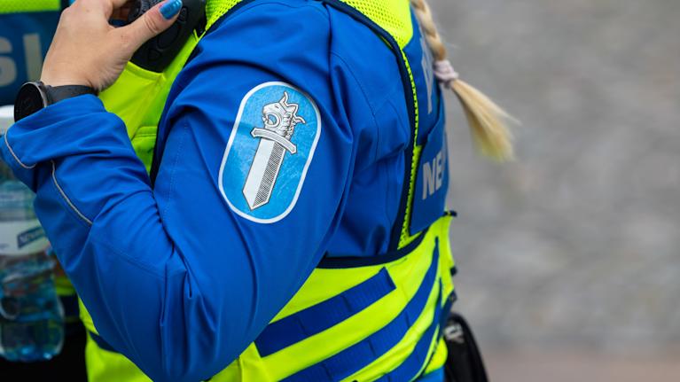 Poliisinainen ja poliisin hihamerkki.