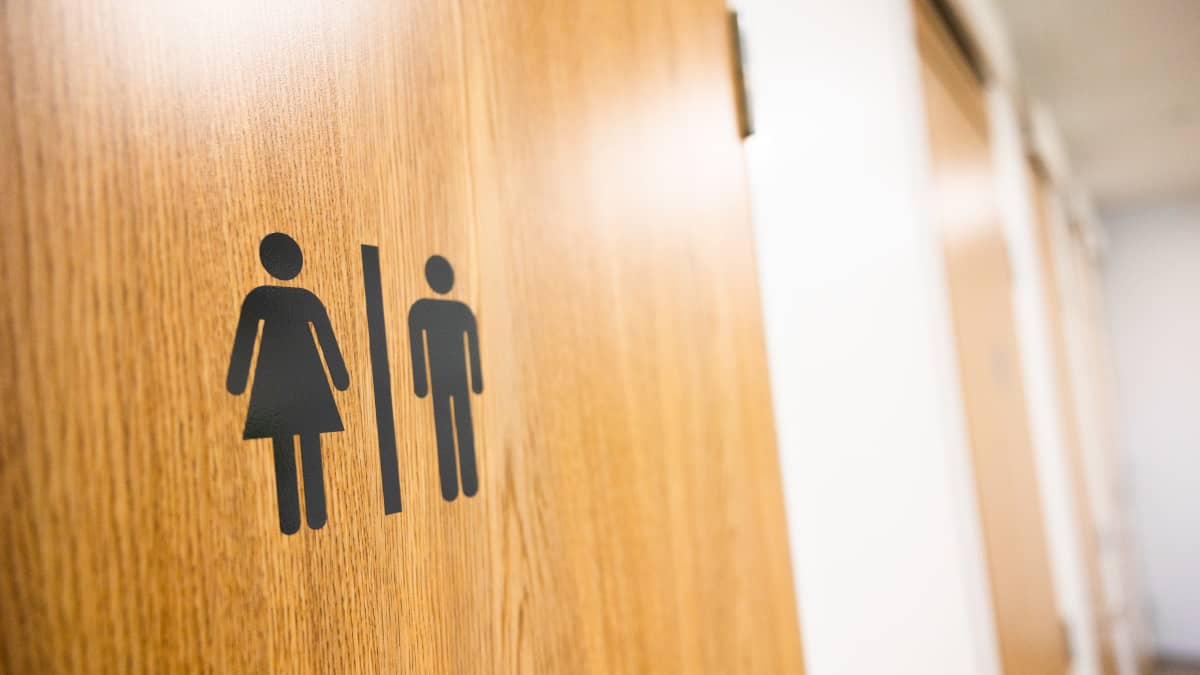 Gender-neutral toilet door at Vuores school. The door shows a graphic that has a female and male shaped figure divided by a line