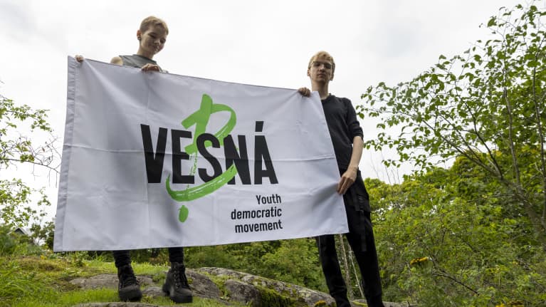 Irina Medvedeva ja Yrii Mironov pitävät käsissään lippua, jossa lukee: "Vesná, youth democratic movement".