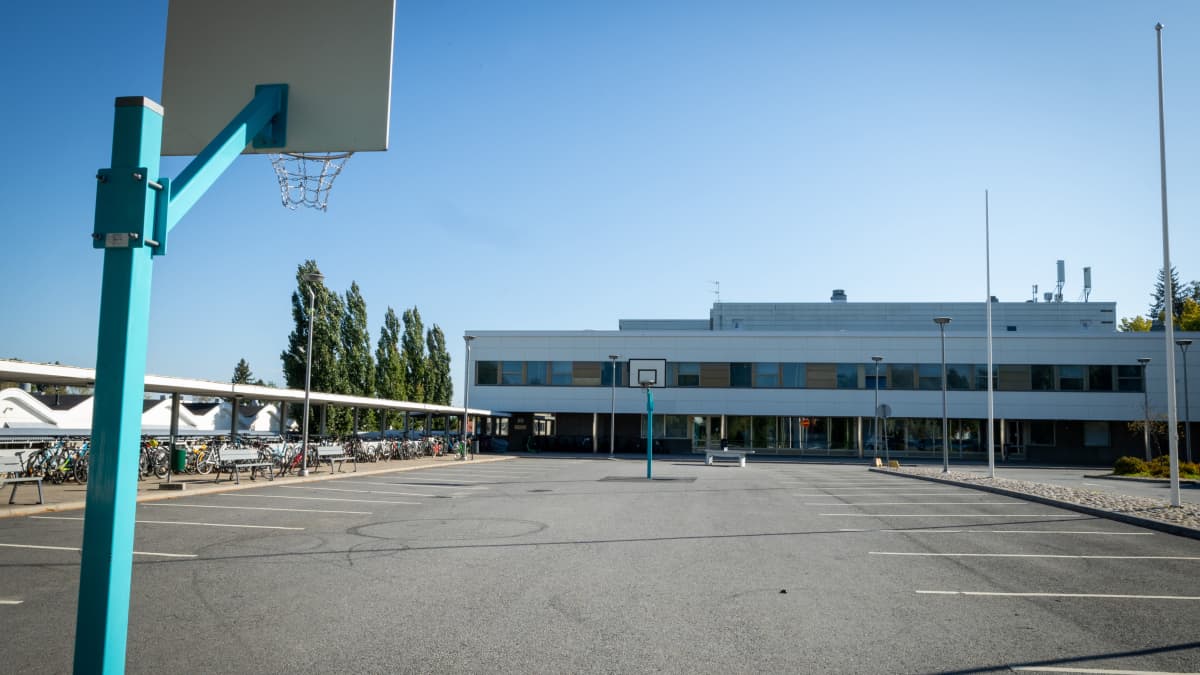 Kuvassa näkyy koulu ja koulun piha. 